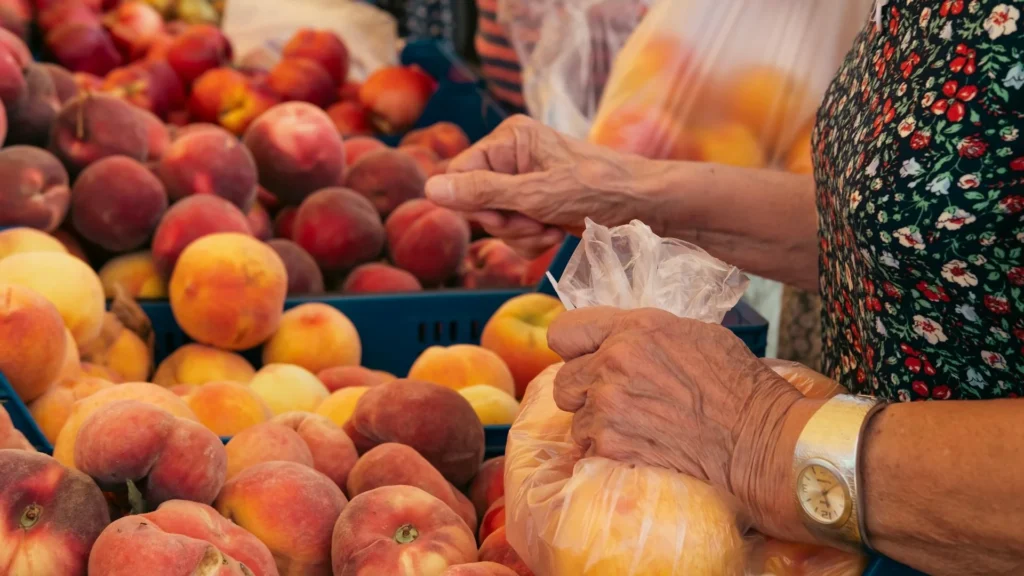 женщина выбирает фрукты в магазине