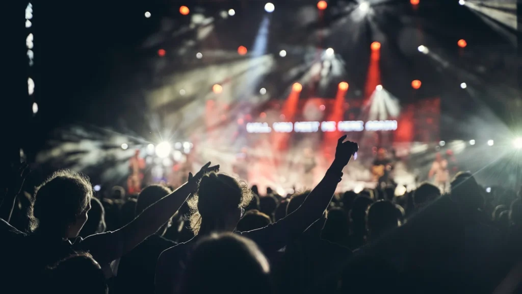 Силуэты людей на музыкальном концерте перед сценой