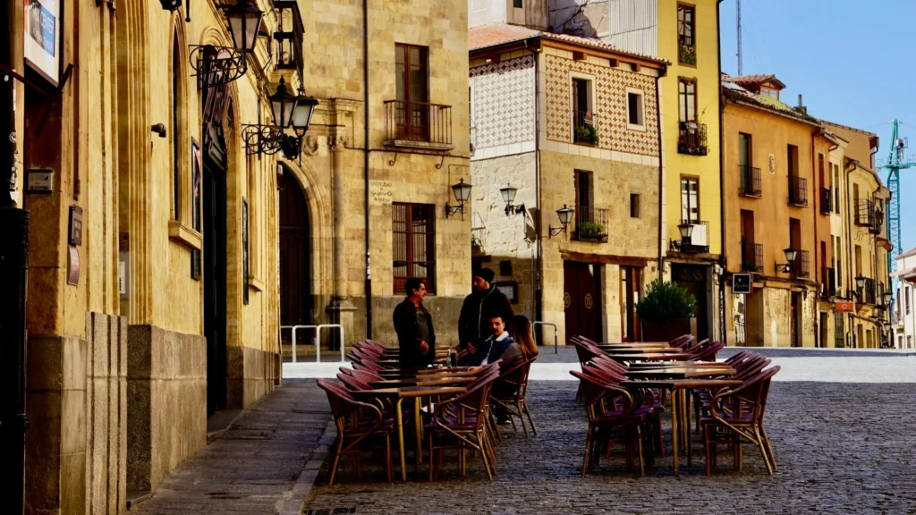 Люди сидят за столиками на летней террасе испанского бара