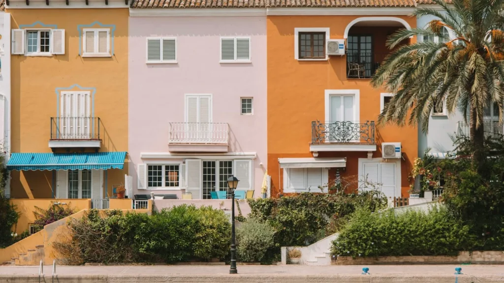 Ряд разноцветных домов на улице с пальмами