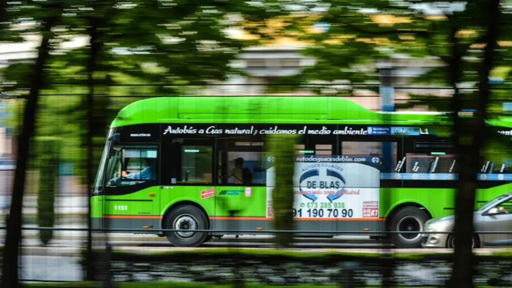 Зеленый автобус едет по городской улице