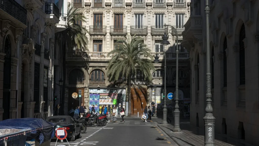 Автомобили, припаркованные вдоль улицы напротив исторического здания