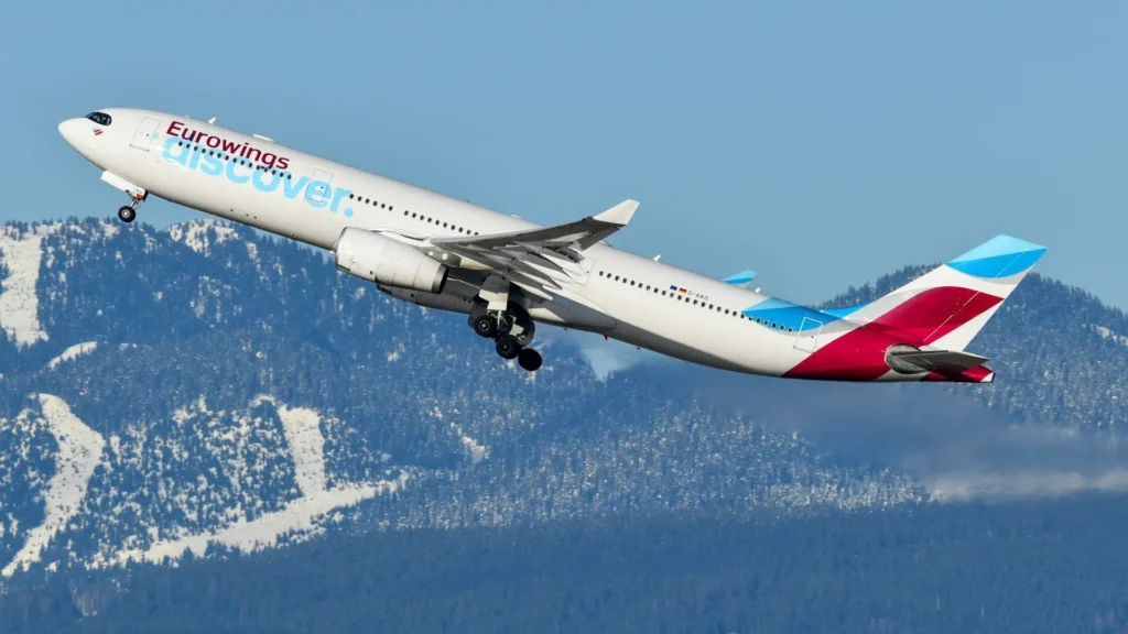 Самолет Eurowings на взлете на фоне гор