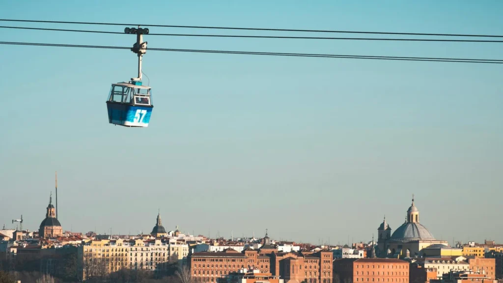 Синяя кабинка канатной дороги над городом