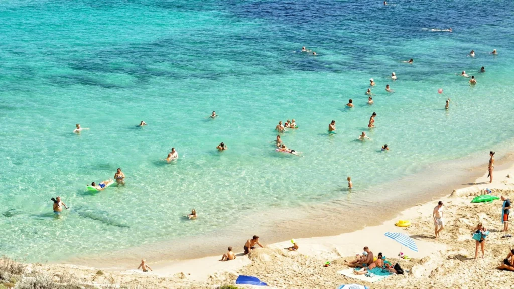 Люди отдыхают на пляже в солнечный день на южном море