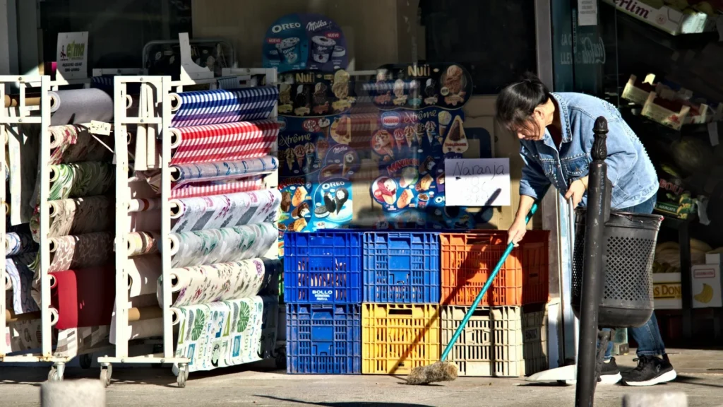 Девушка подметает перед магазином