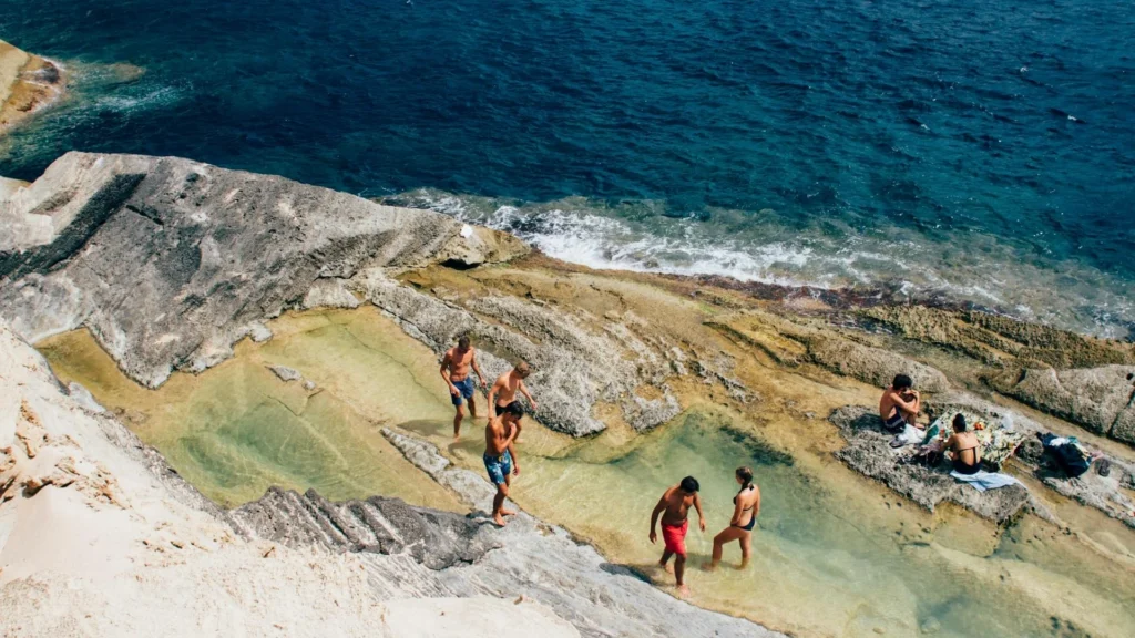 Туристы в купальниках на скалах у моря