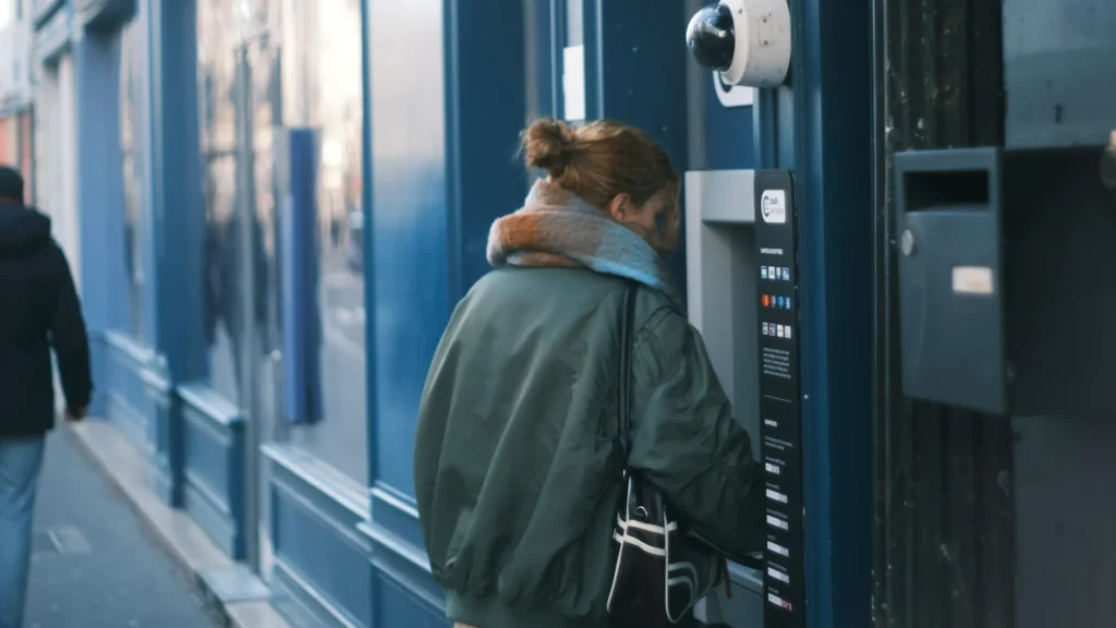 Девушка пользуется банкоматом на улице