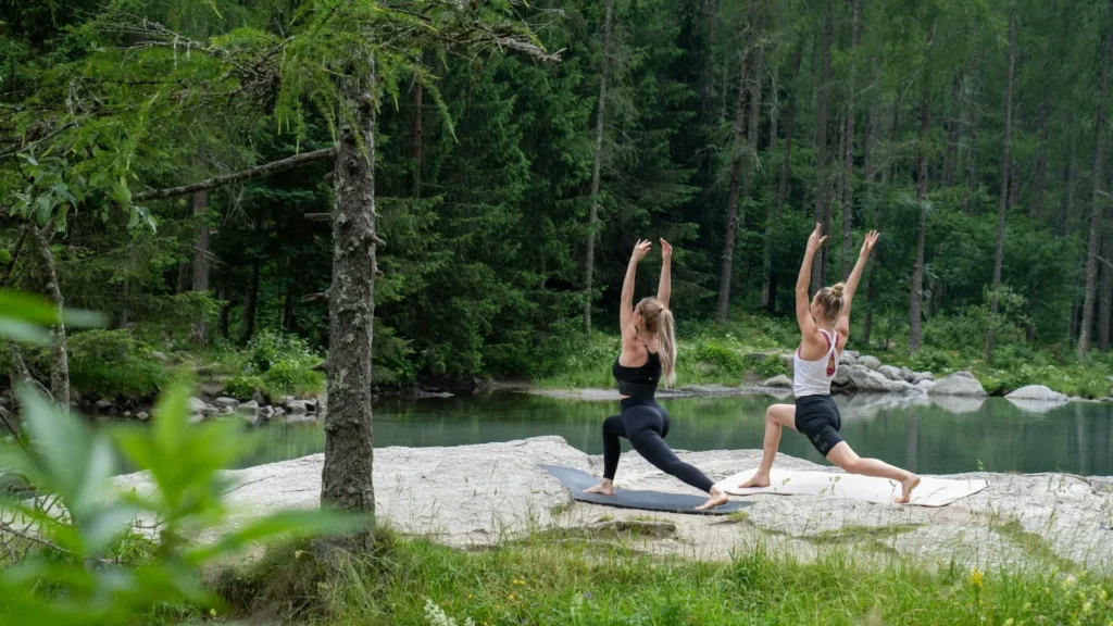 Две девушки занимаются йогой в природном парке