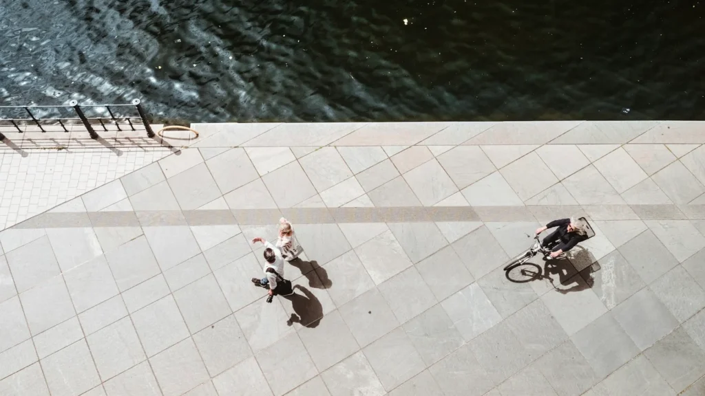 Вид сверху на идущих по набережной людей