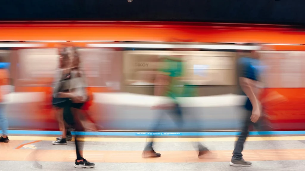 Размытые силуэты людей на фоне поезда