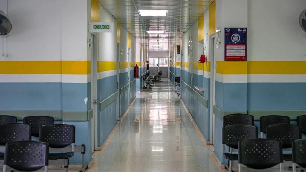 Интерьер больницы, коридор, черные стулья