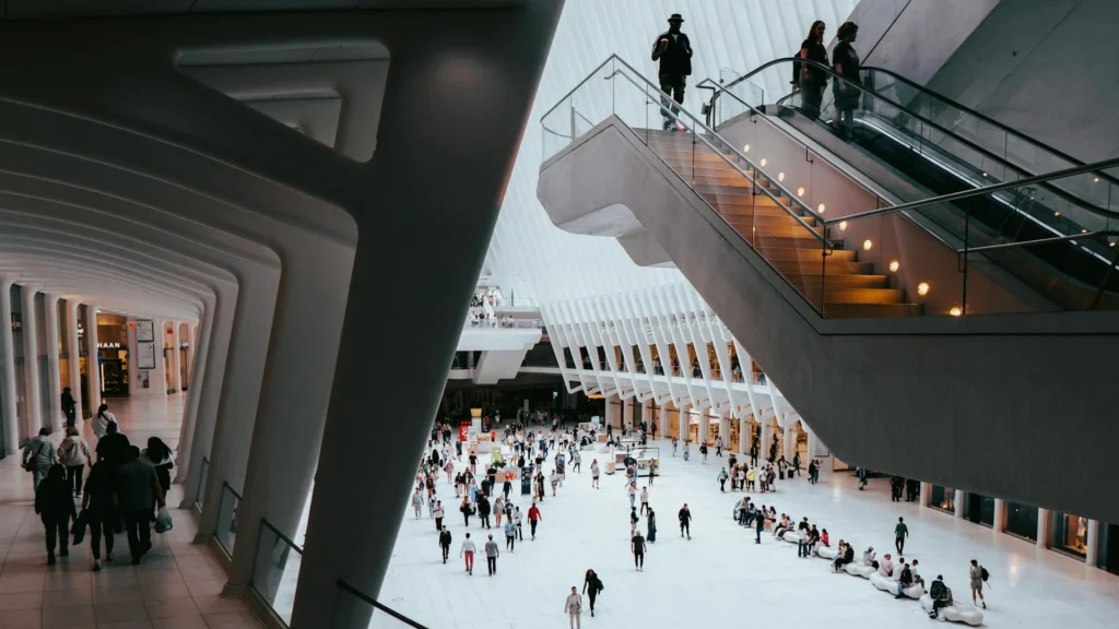 Посетители внутри торгового центра, эскалатор