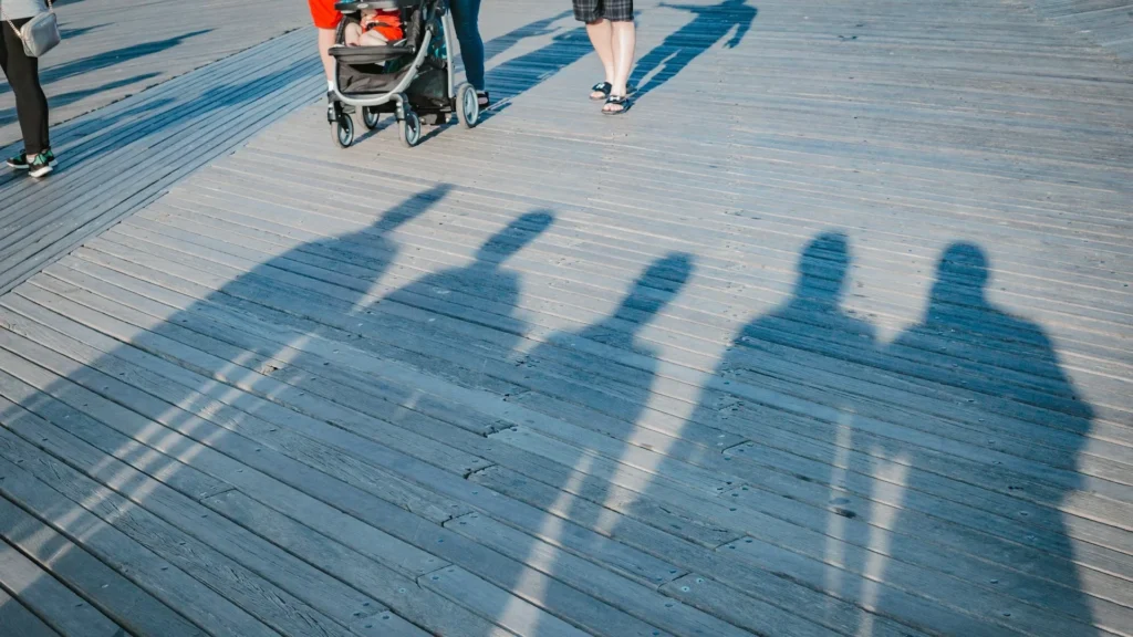 Ноги людей, коляска, тени людей на променаде