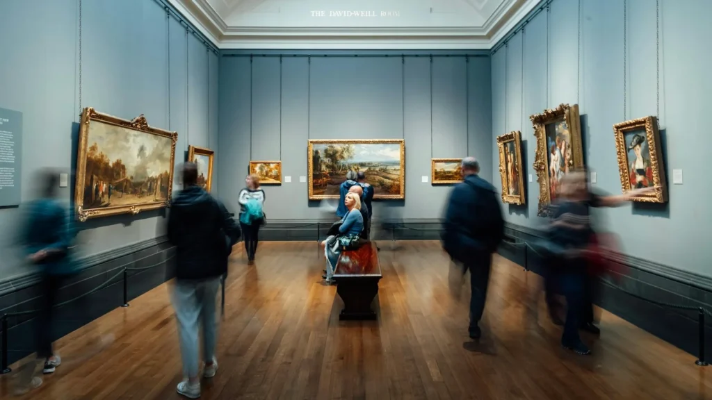 Посетители музея искусства смотрят на картины в голубом зале