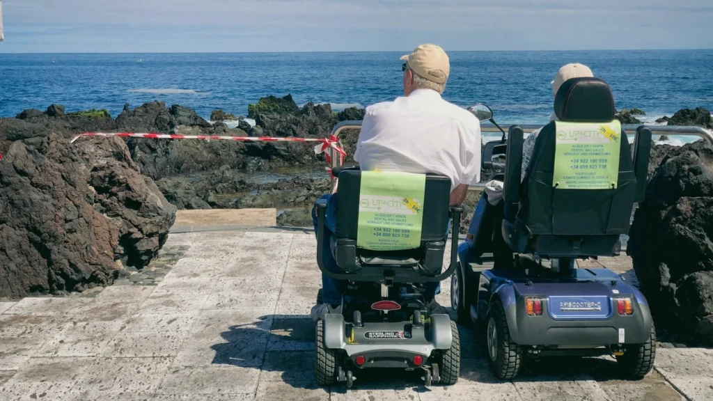 Пара пенсионеров-инвалидов смотрит на море