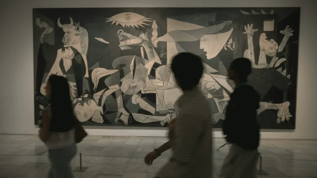 Черно-белое фото картины Пабло Пикассо "Герника", люди в музее