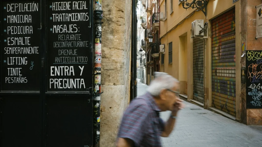 пожилой мужчина идет по испанской улице