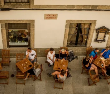 туристы сидят за столиками кафе на улице в испании