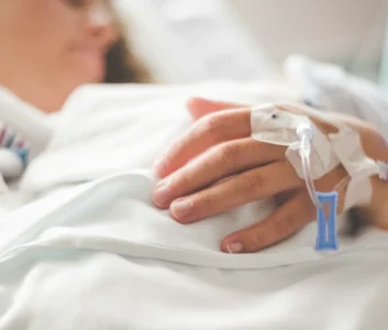 пациентка больницы лежит в кровати с катетором