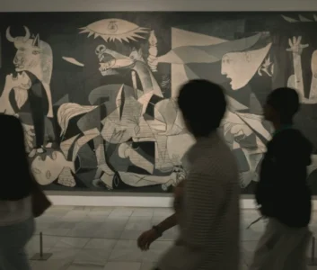 Черно-белое фото картины Пабло Пикассо "Герника", люди в музее