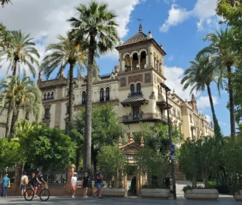 Историческое здание в центре Севильи среди пальм