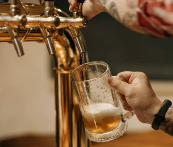 Рука бармена, наливающего пиво в стакан